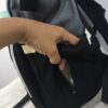 práctica mochila pañalera destaca por su diseño bicolor en tela gris texturizada
