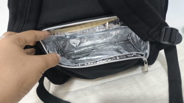 práctica mochila pañalera destaca por su diseño bicolor en tela gris texturizada