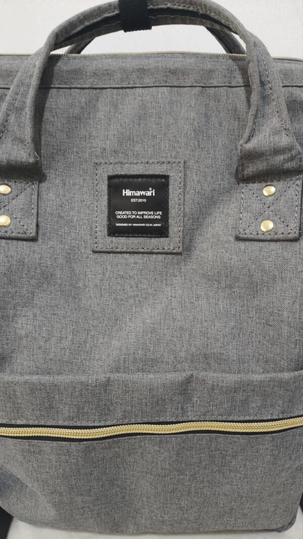 mochila y pañalera gris de lona de la marca Himawari con detalles dorados