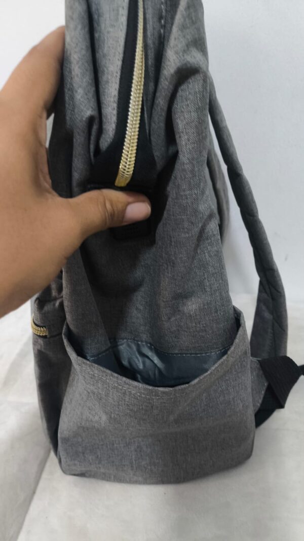 2026/10/1000786607.jpg mochila pañalera multifuncional de color gris melange con detalles dorados y cambiador portatil
